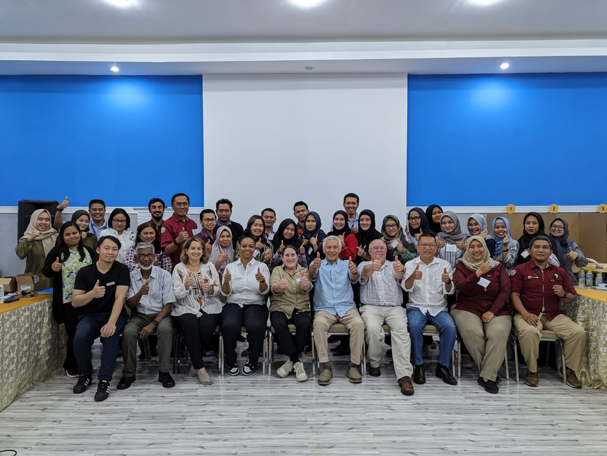 Group photo of the training participants giving a thumbs up.