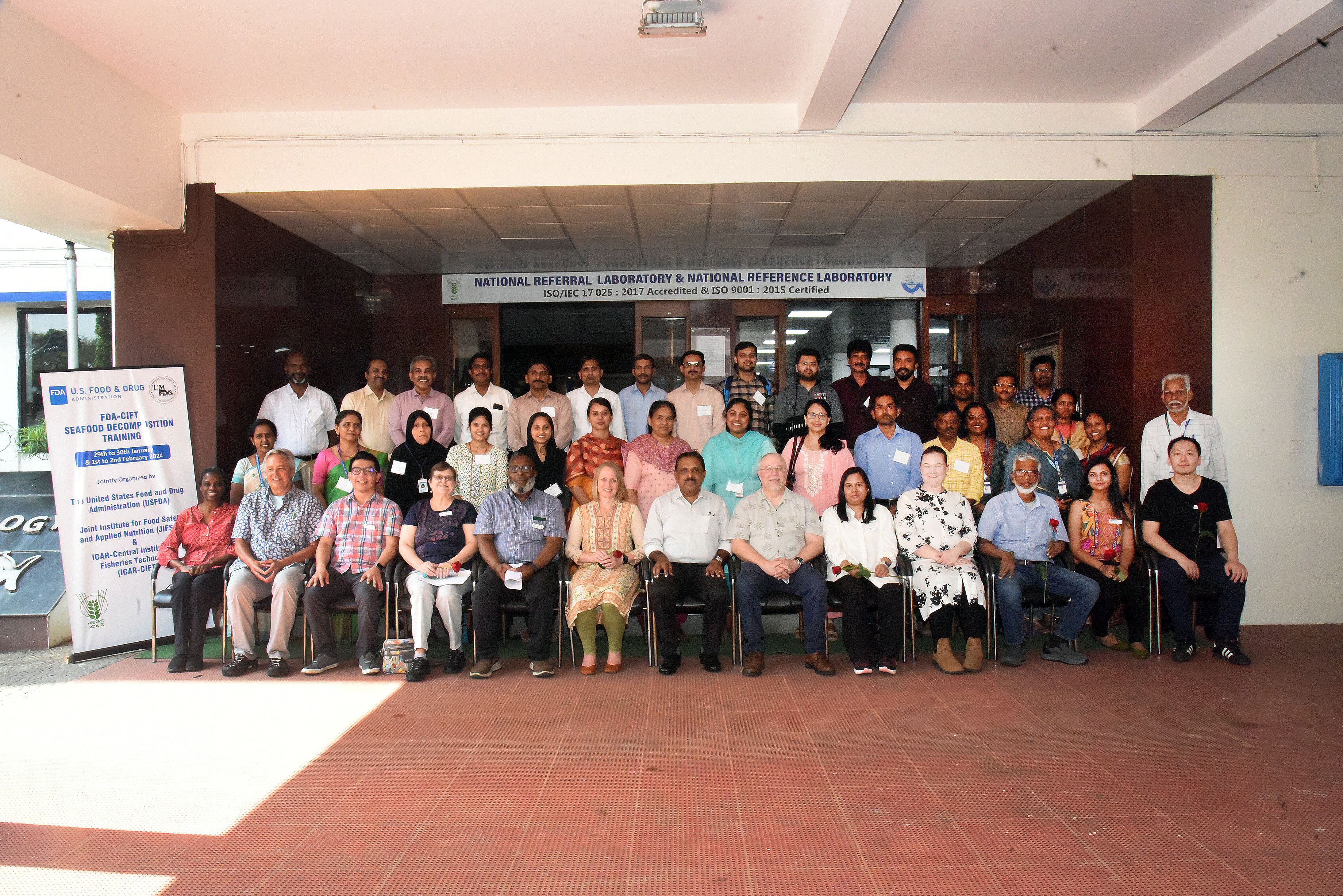 Group photo of the training participants in front of a sign reading National Referral Laboratory & National Reference Laboratory.