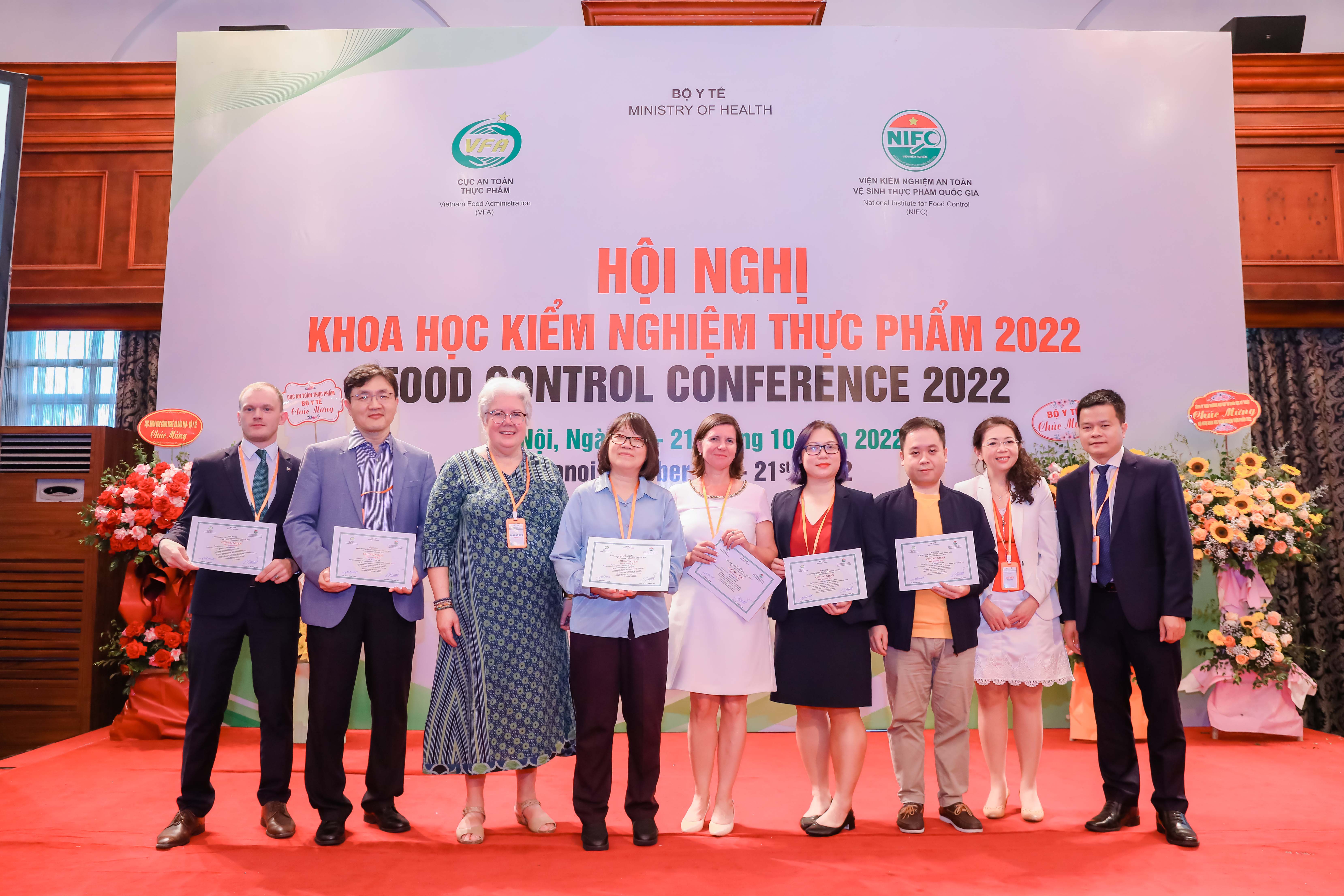 Dr. Clare Narrod with Food Control Conference participants holding certificates.